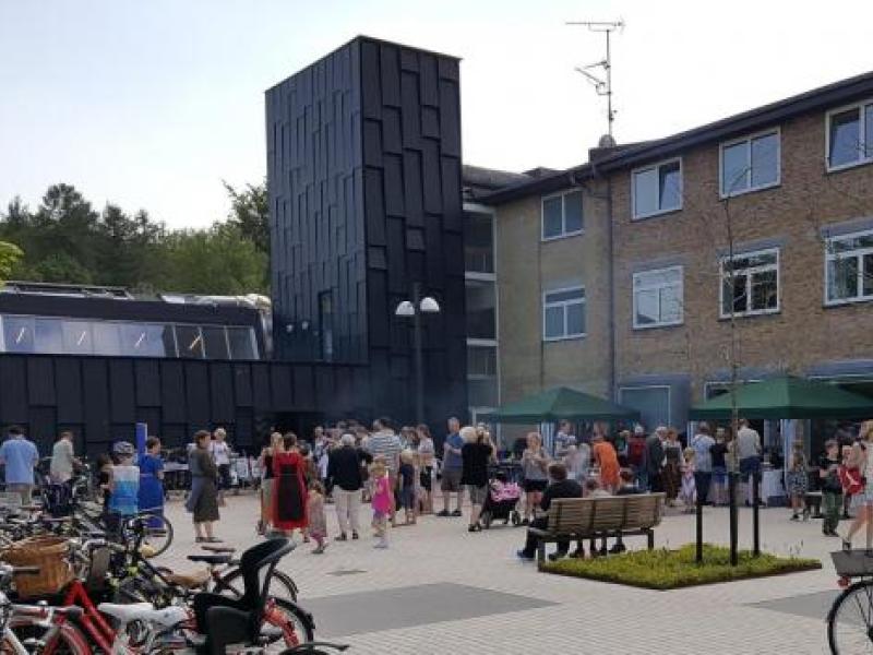 Arkivfoto af Allerød Bibliotek med mennesker på pladsen foran bygningen.
